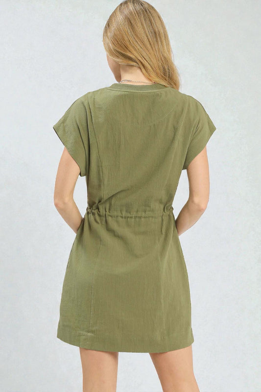 Woman wearing a green dress against a plain background