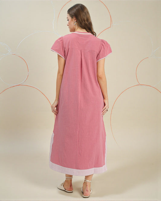 Woman wearing a pink dress with white trim on a beige background