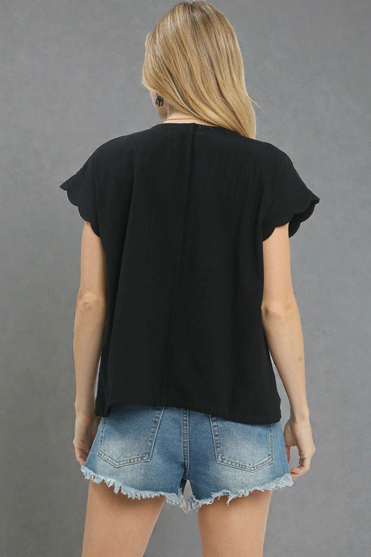 Person wearing a black top and denim shorts on a gray background