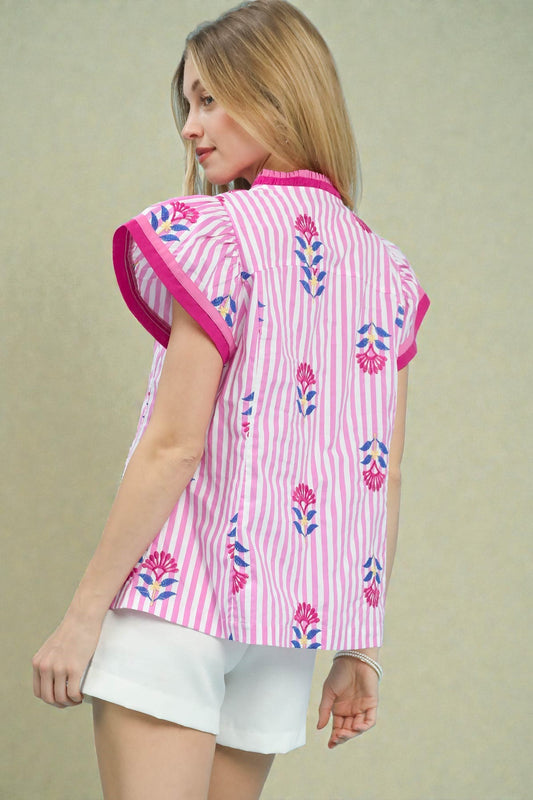 Woman wearing a pink and white striped shirt with floral patterns on a beige background