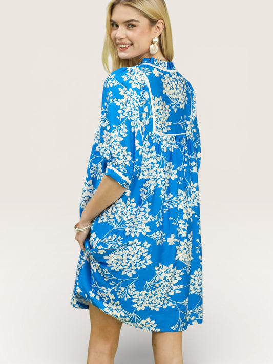 Woman wearing a blue floral dress on a white background