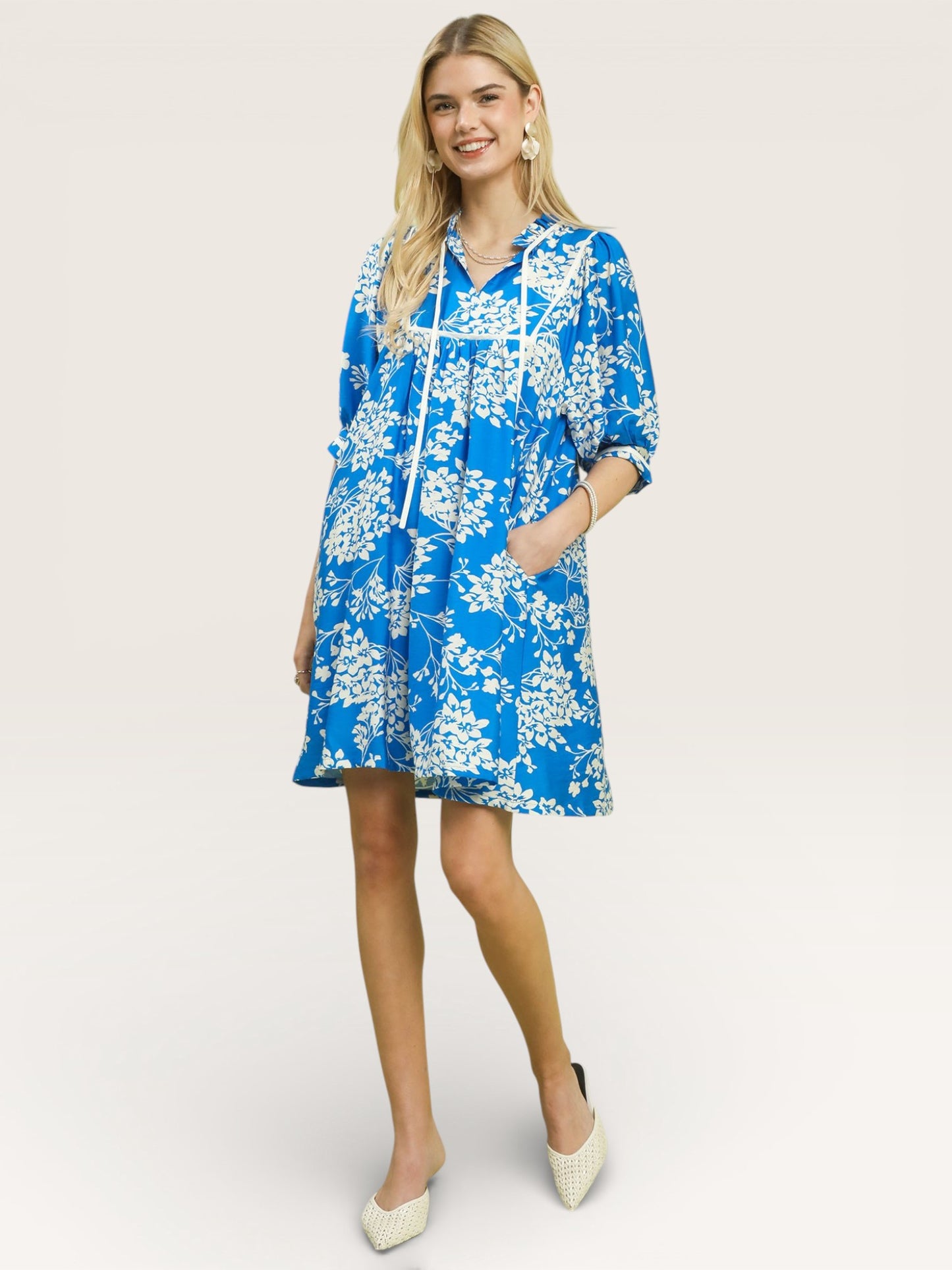 Woman wearing a blue floral dress on a white background