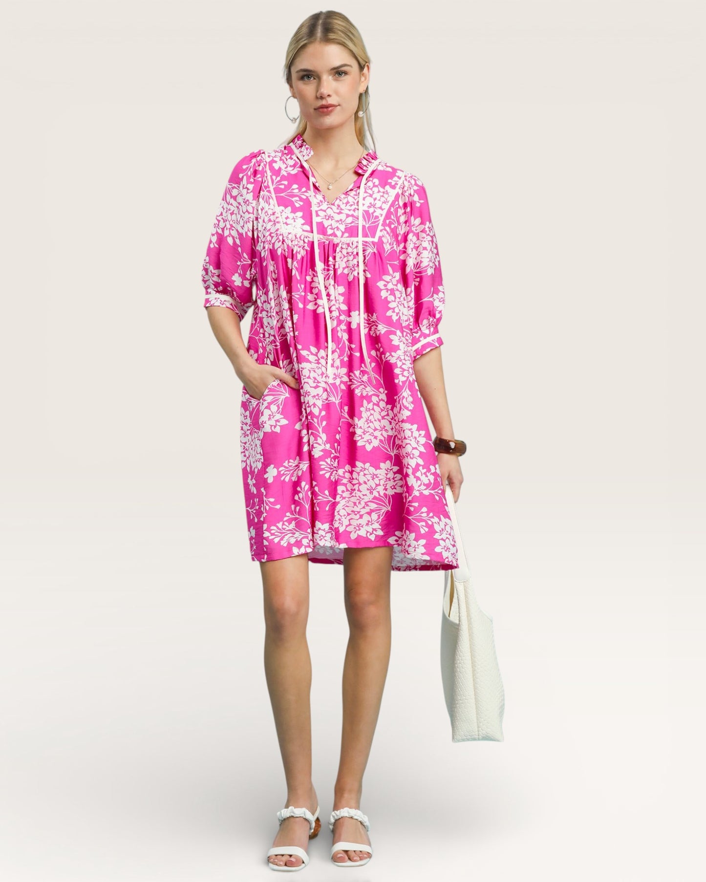 Woman wearing a pink floral dress on a white background