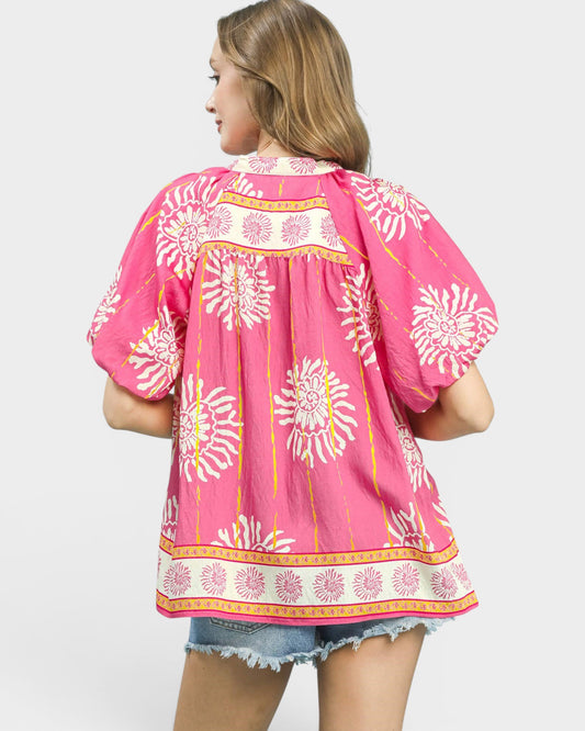 Woman wearing a pink floral patterned top on a white background