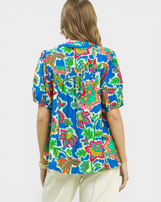 Person wearing a colorful floral shirt on a white background