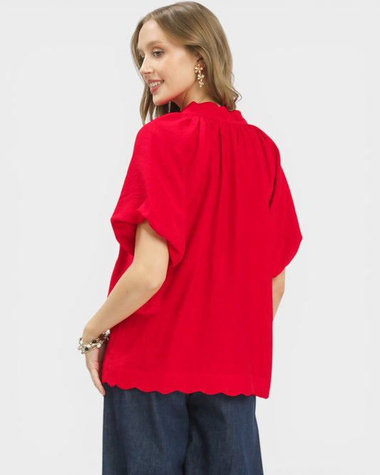 Woman wearing a red blouse with a plain background