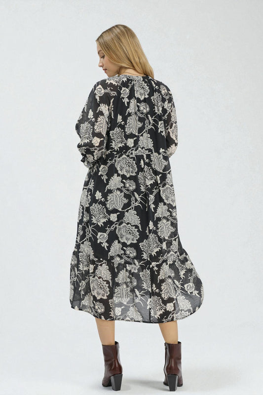 Woman wearing a black floral dress on a white background