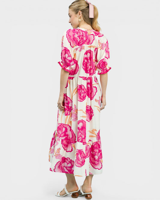 Woman wearing a floral dress with pink flowers on a white background
