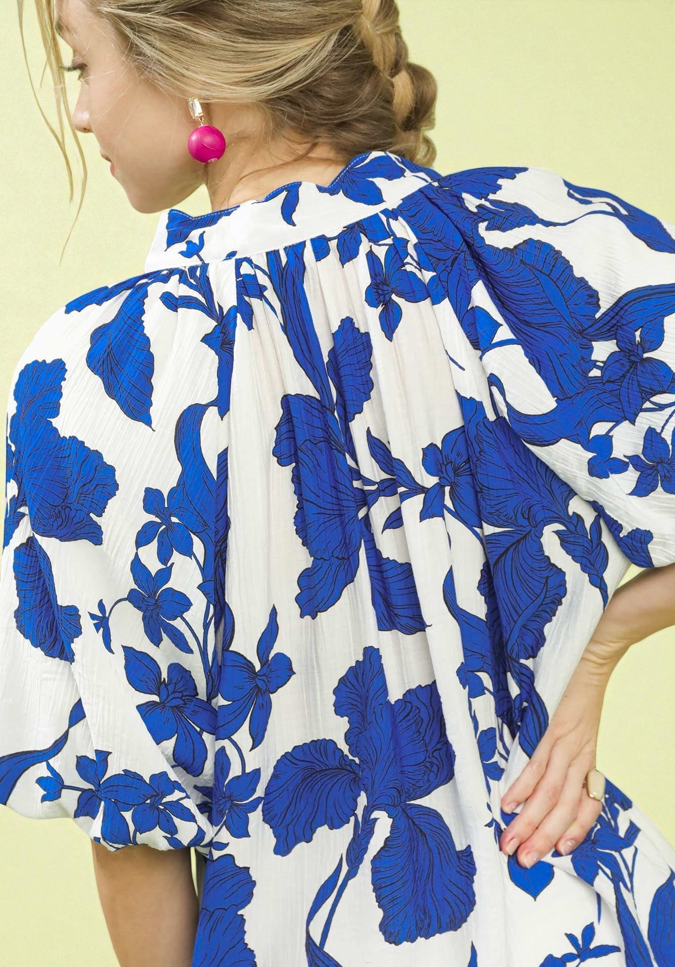 Woman wearing a blue and white floral dress on a yellow background