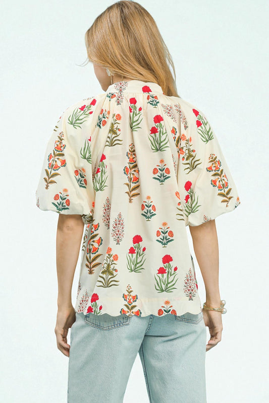 Person wearing a floral blouse with a plain background