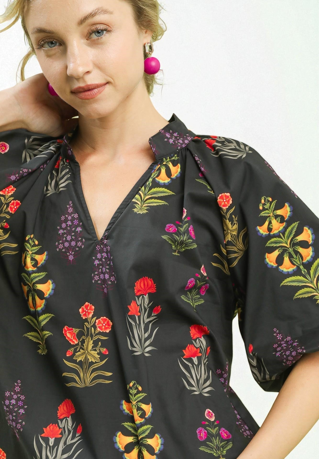 Woman wearing a black floral embroidered dress against a white background