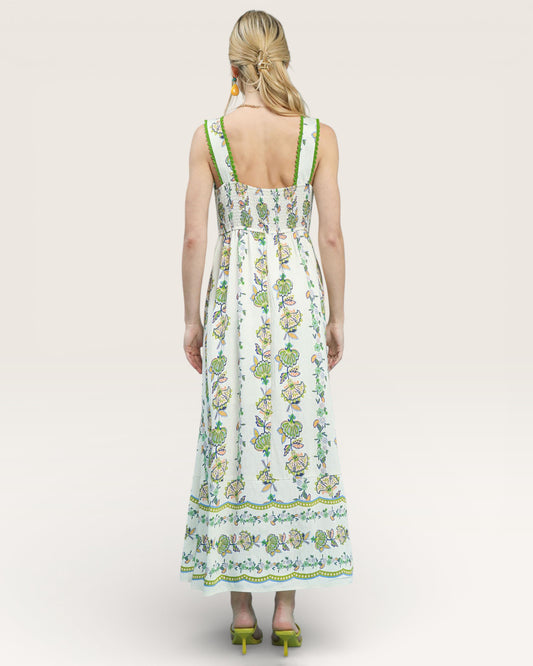 Woman wearing a floral dress with green accents on a white background