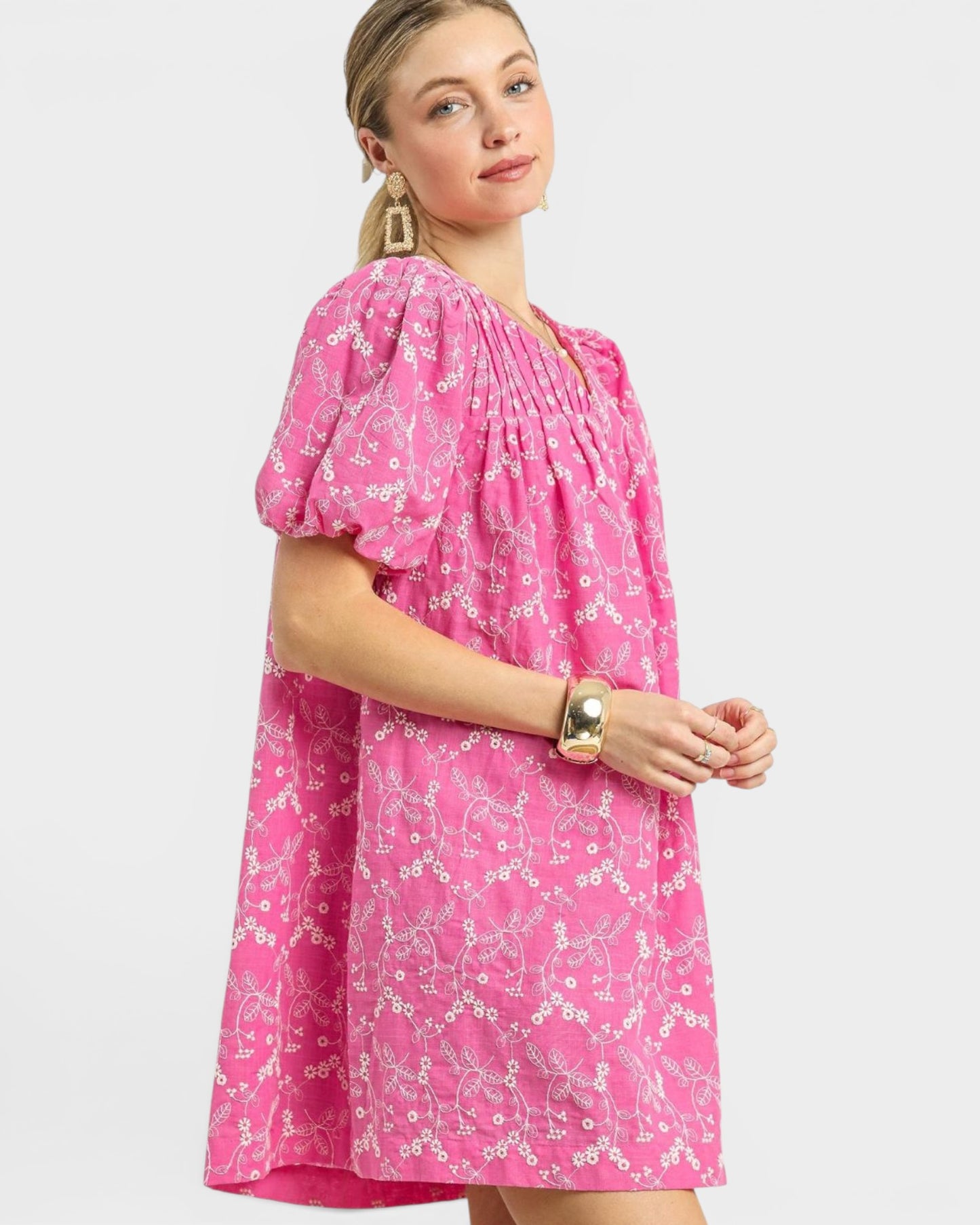 Woman wearing a pink floral dress on a white background