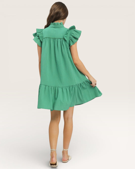 Green dress with ruffled sleeves and bottom on a white background