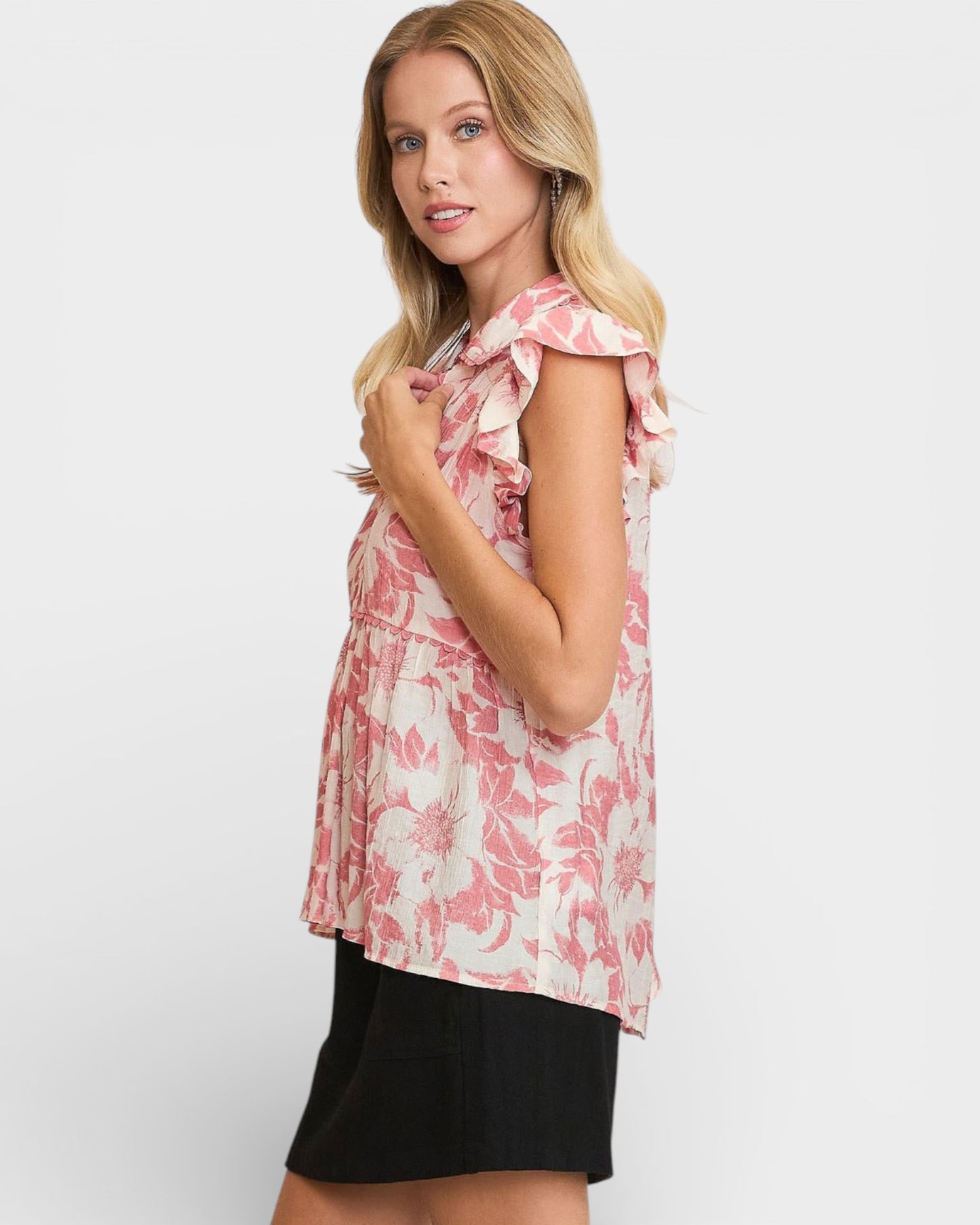 Woman wearing a pink floral top with a white background