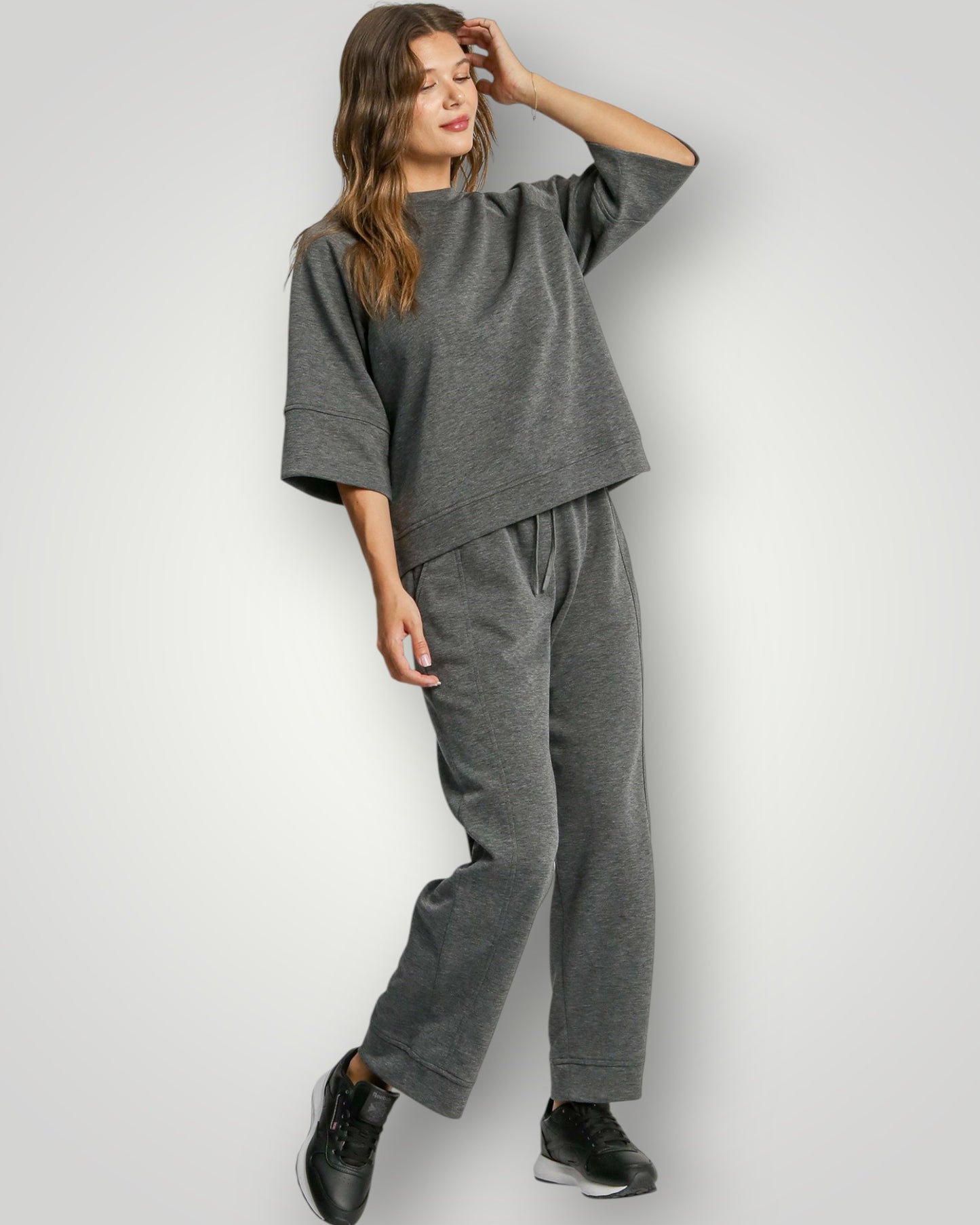 Woman wearing a gray outfit on a white background