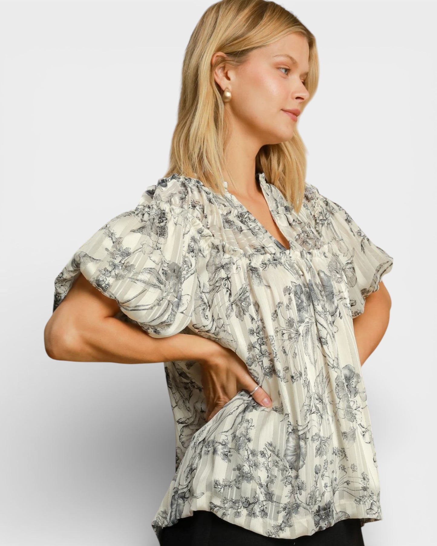 Woman wearing a floral blouse against a plain background