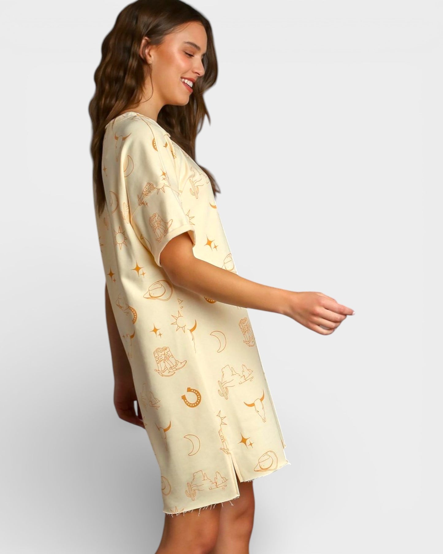 Woman wearing a light-colored dress with patterns on a plain background