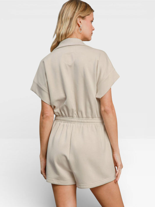 Woman wearing a beige romper on a white background