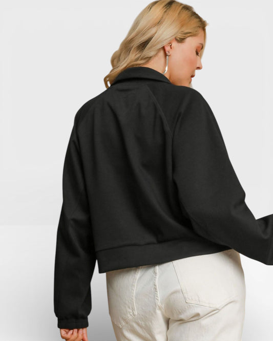 Person wearing a black jacket and white pants on a light gray background