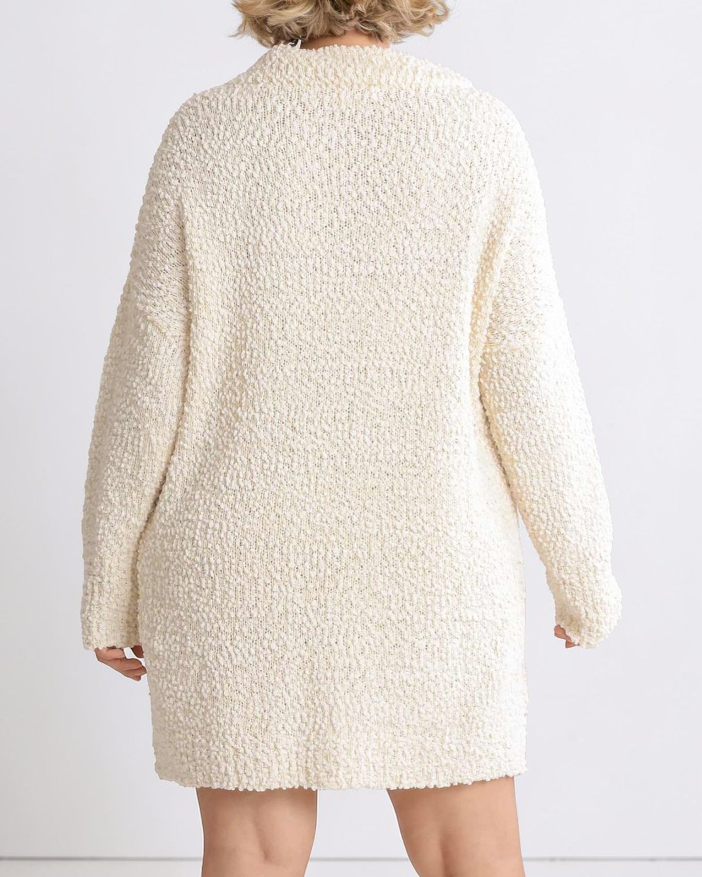 Beige textured dress worn by a person on a white background