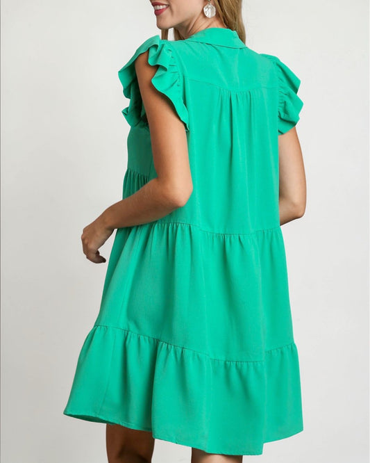Green dress with ruffled sleeves on a plain background