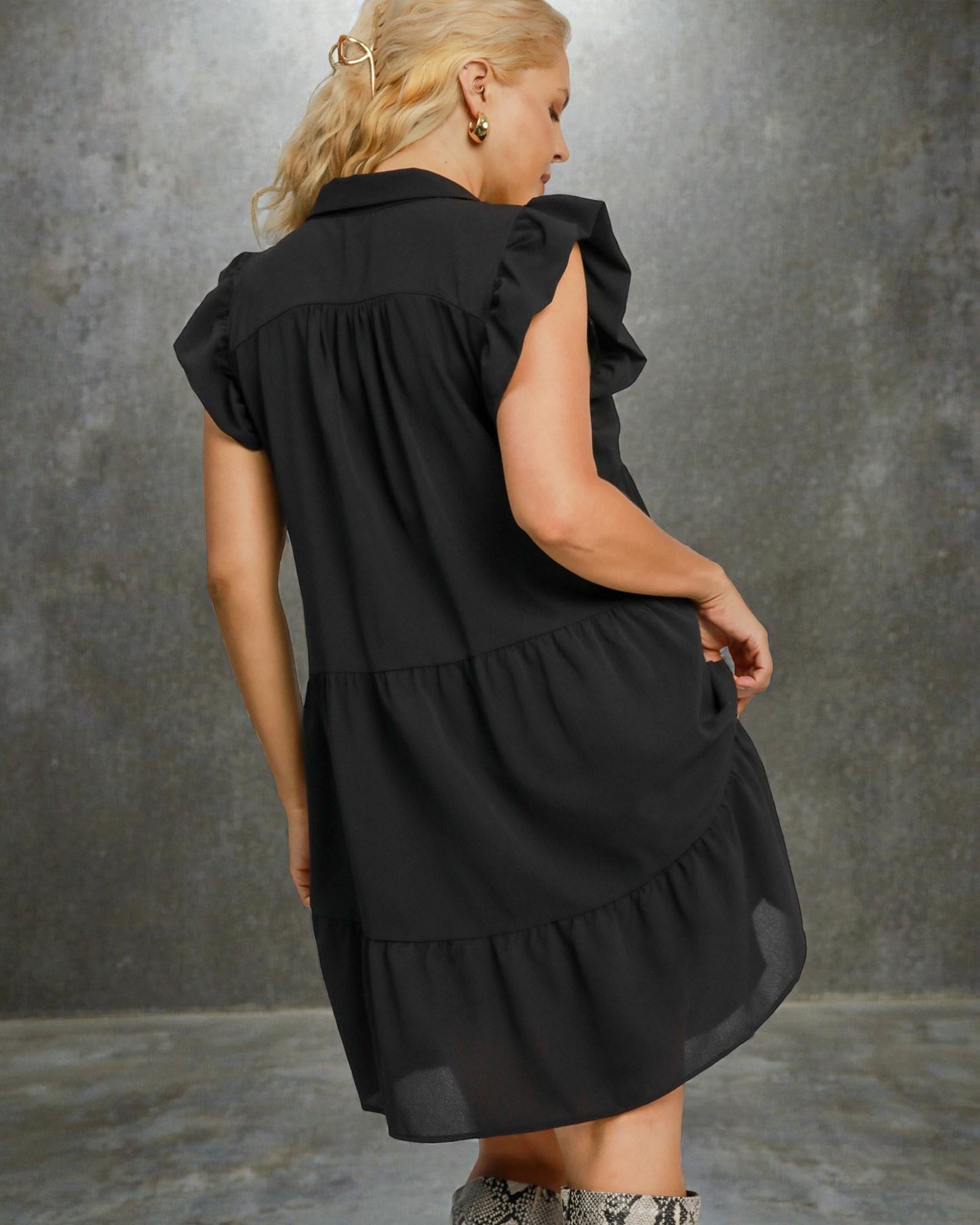 Woman wearing a black dress against a gray background