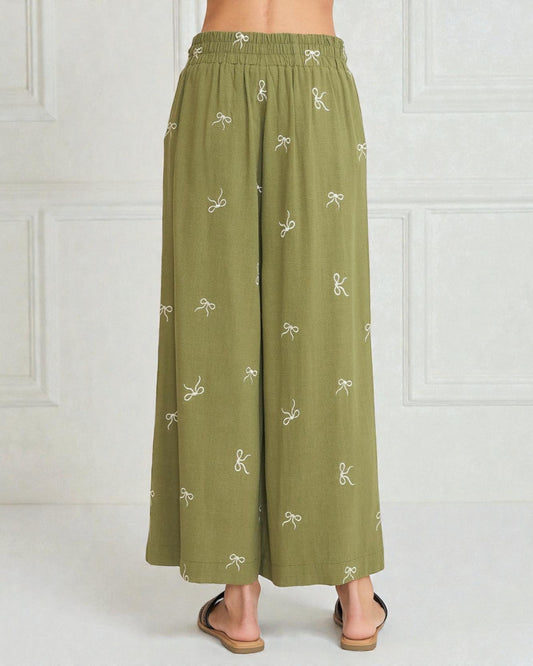 Green wide-leg pants with white patterns on a white background