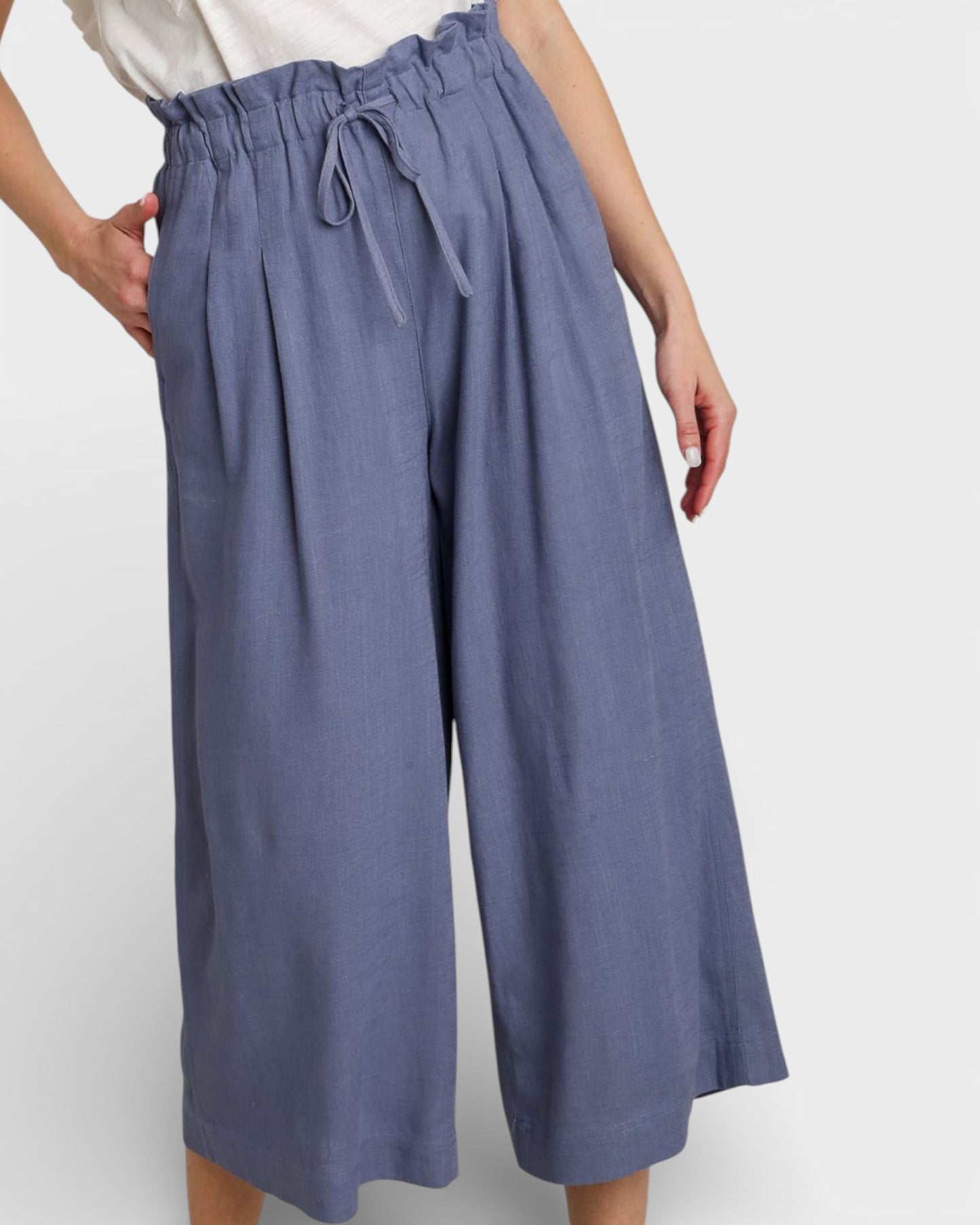 Blue wide-leg pants worn by a person on a white background