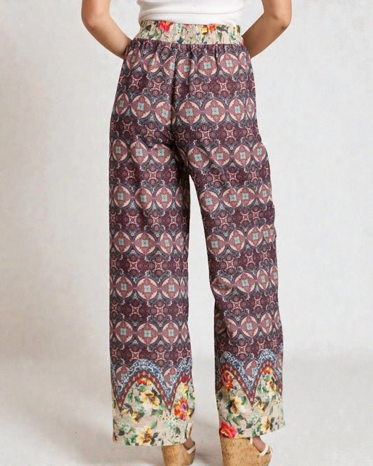 Patterned pants with a colorful waistband on a plain background
