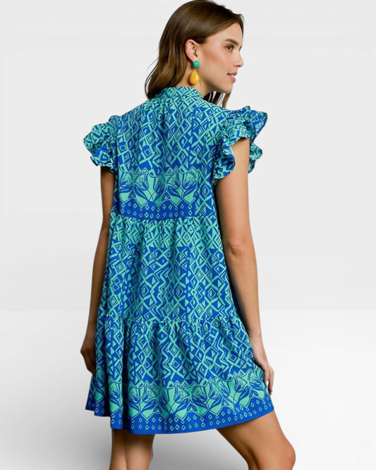 Woman wearing a blue and green patterned dress on a white background