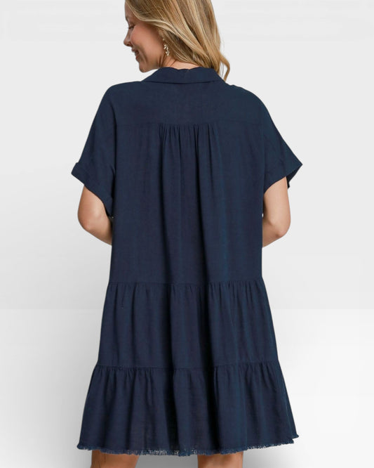Navy blue tiered dress worn by a person on a white background