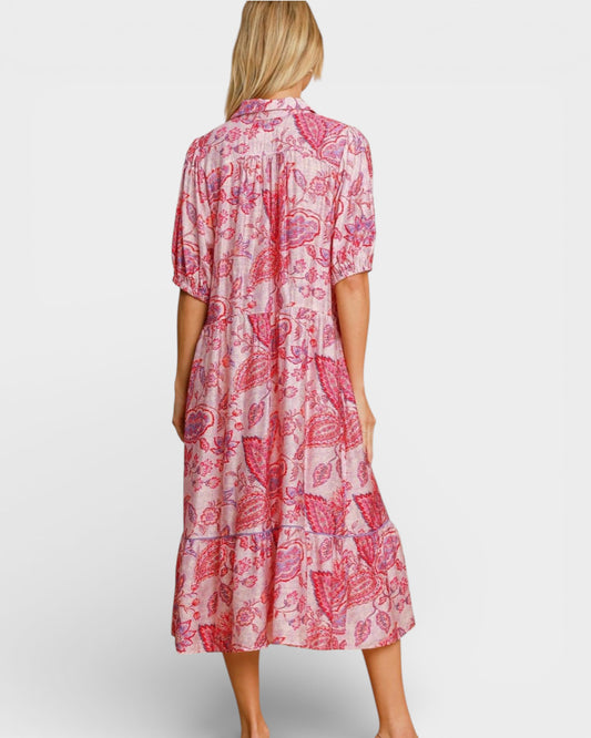 Woman wearing a pink and white floral dress on a plain background