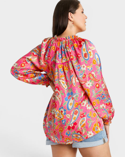 Woman wearing a colorful patterned blouse on a white background