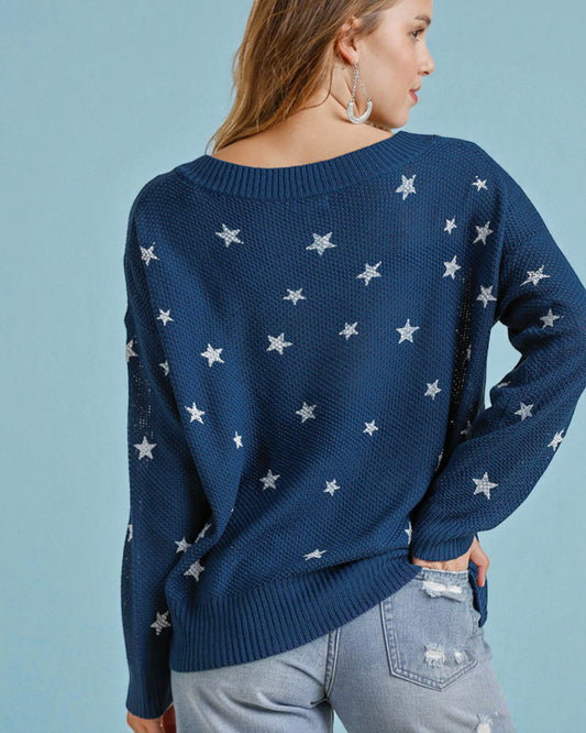 Person wearing a navy blue sweater with star patterns on a light blue background