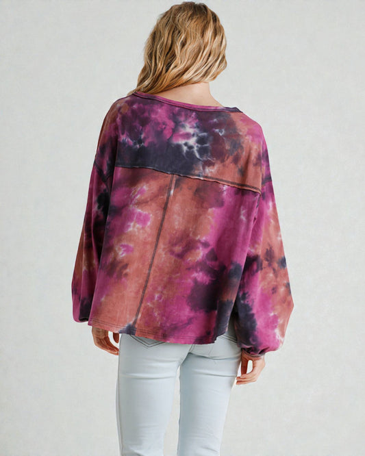 Person wearing a tie-dye shirt with a plain background