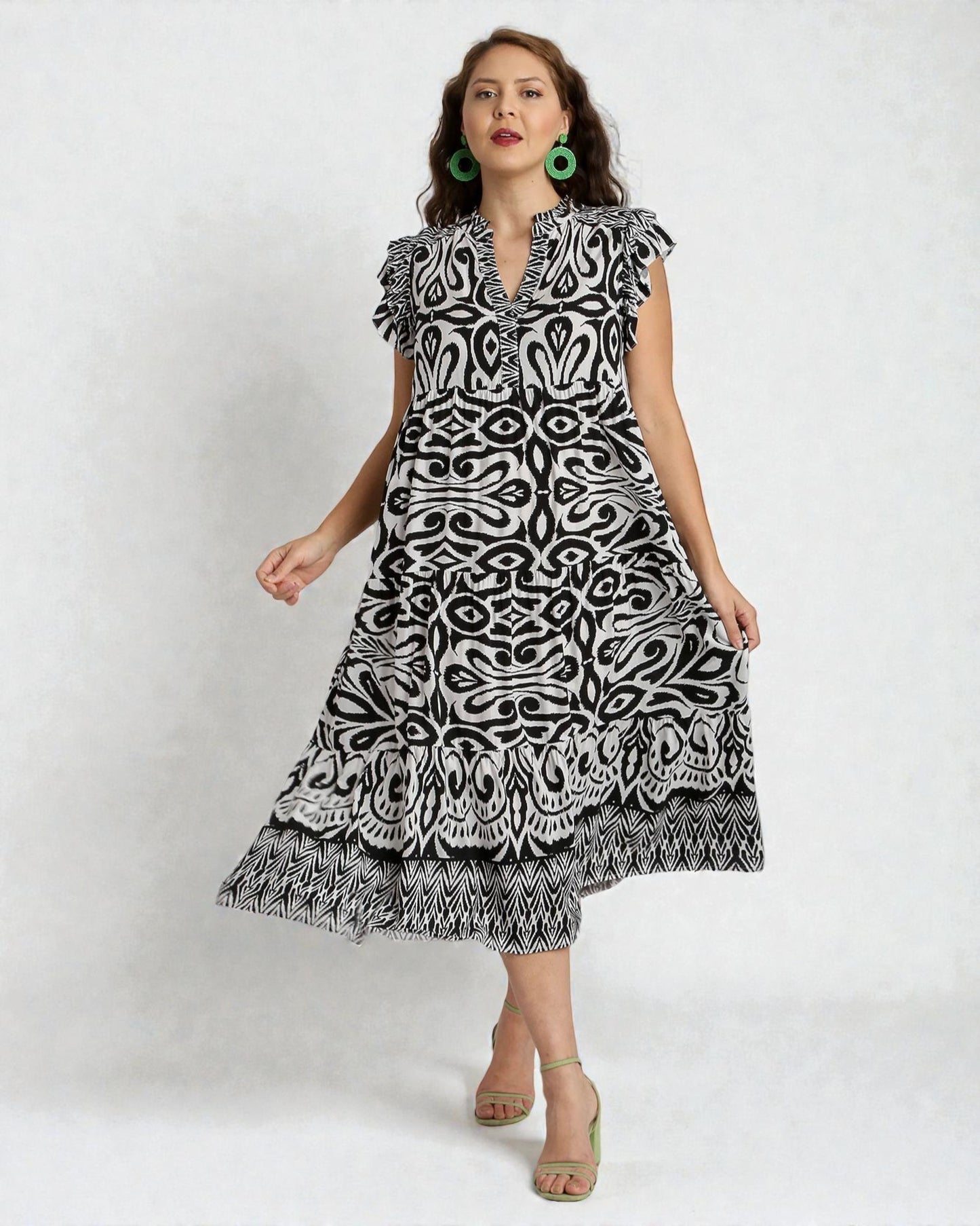 Woman wearing a black and white patterned dress on a white background