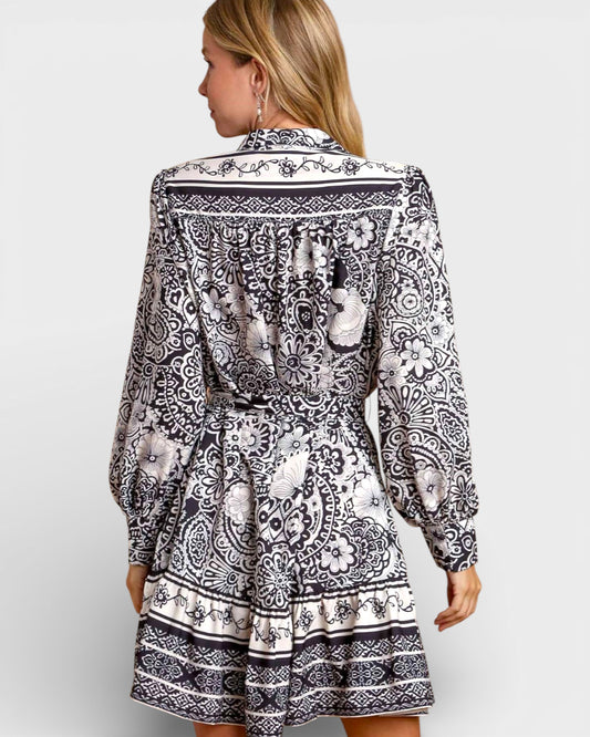 Woman wearing a black and white patterned dress on a white background