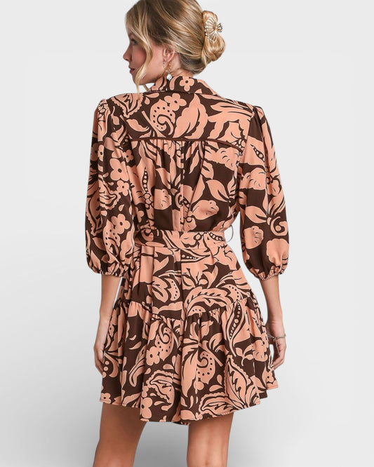 Woman wearing a patterned dress on a plain background