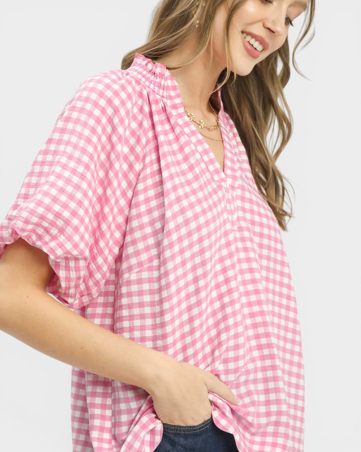 Woman wearing a pink gingham shirt on a white background