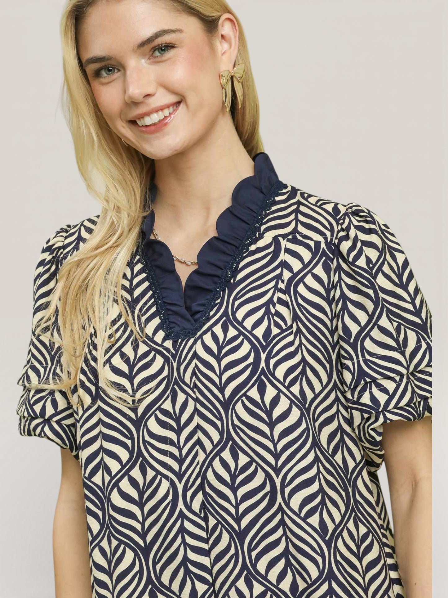 Woman wearing a patterned blouse with a plain background