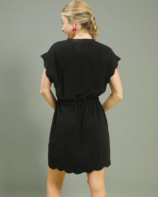 Woman wearing a black dress against a gray background