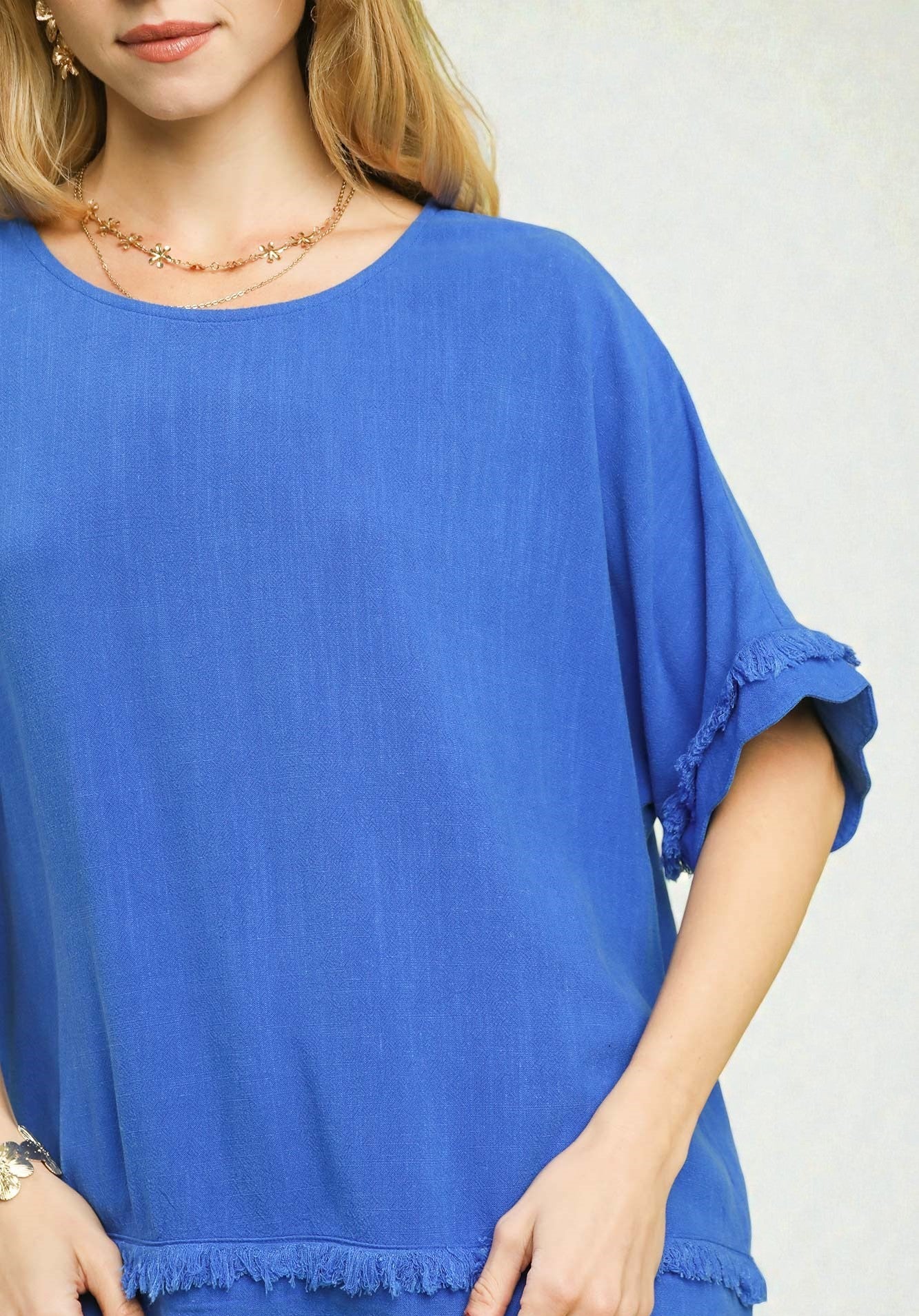 Blue top worn by a person on a plain background