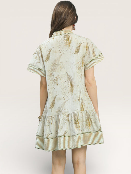 Woman wearing a patterned dress with a plain background