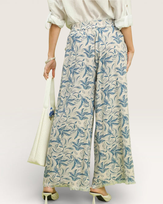 Person wearing floral-patterned pants with a plain background