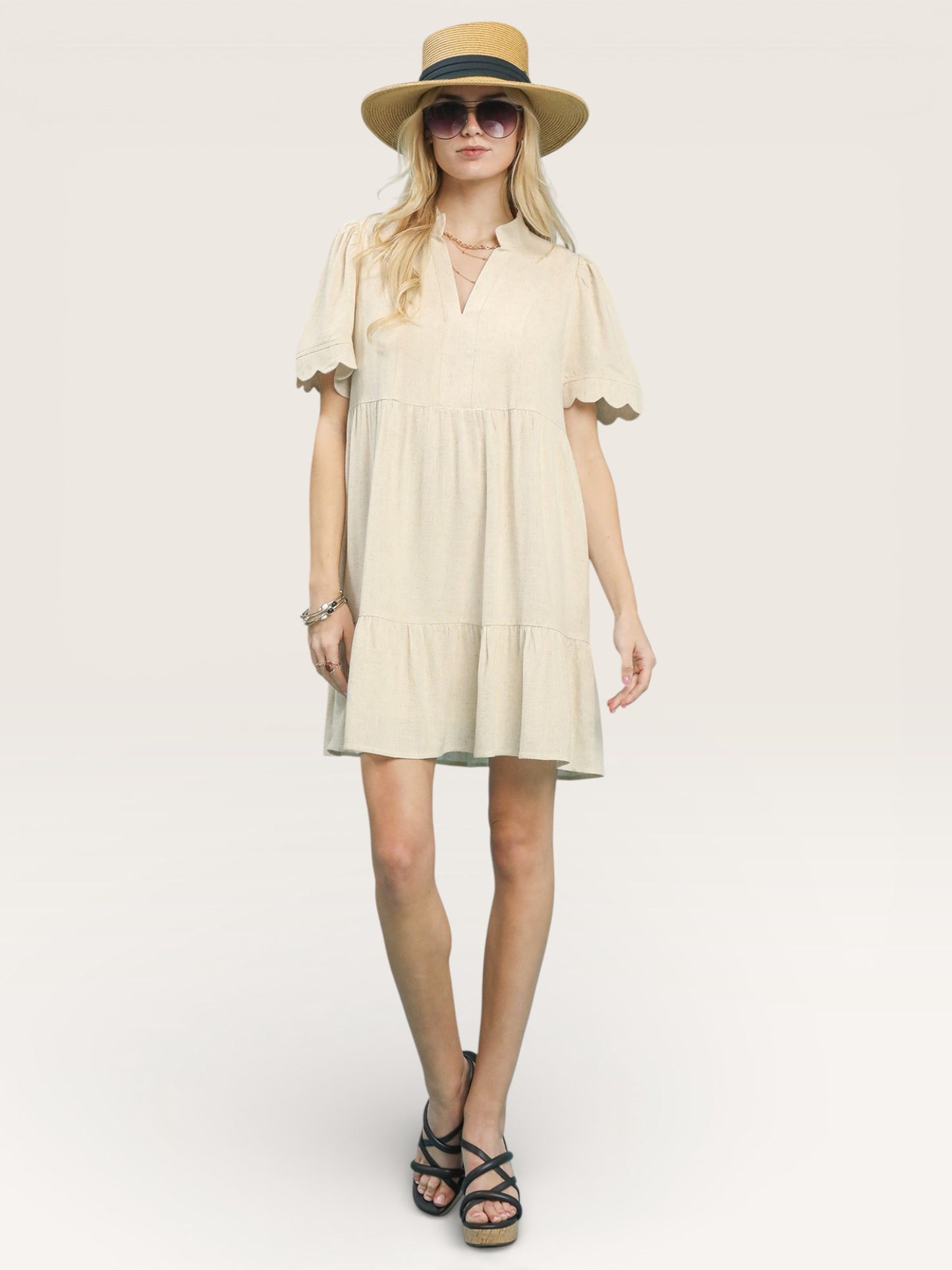 Woman wearing a beige dress and hat on a white background