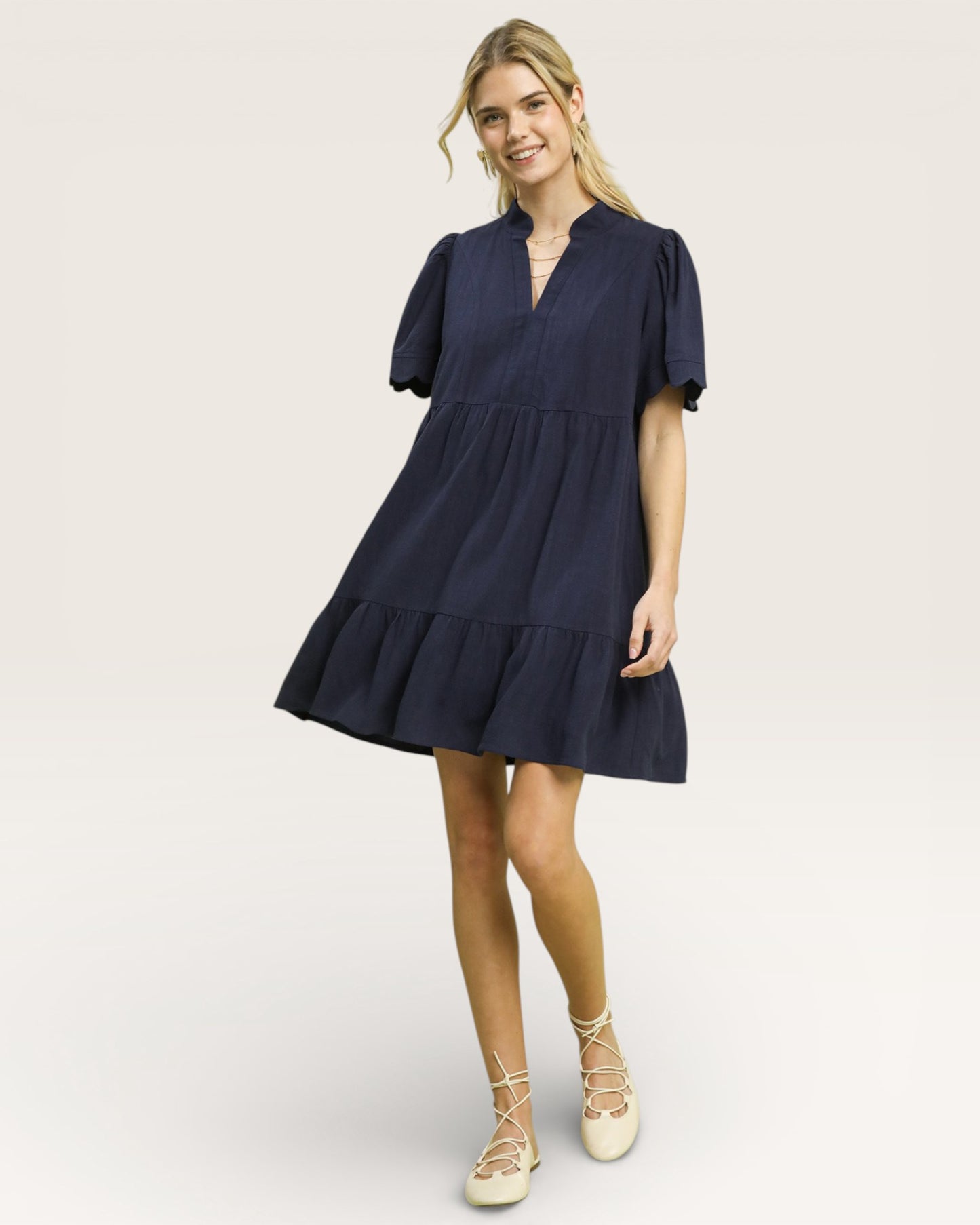 Woman wearing a navy blue dress on a plain background