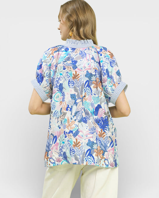 Person wearing a colorful patterned shirt with a white background