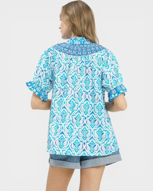 Person wearing a blue and white patterned shirt on a white background