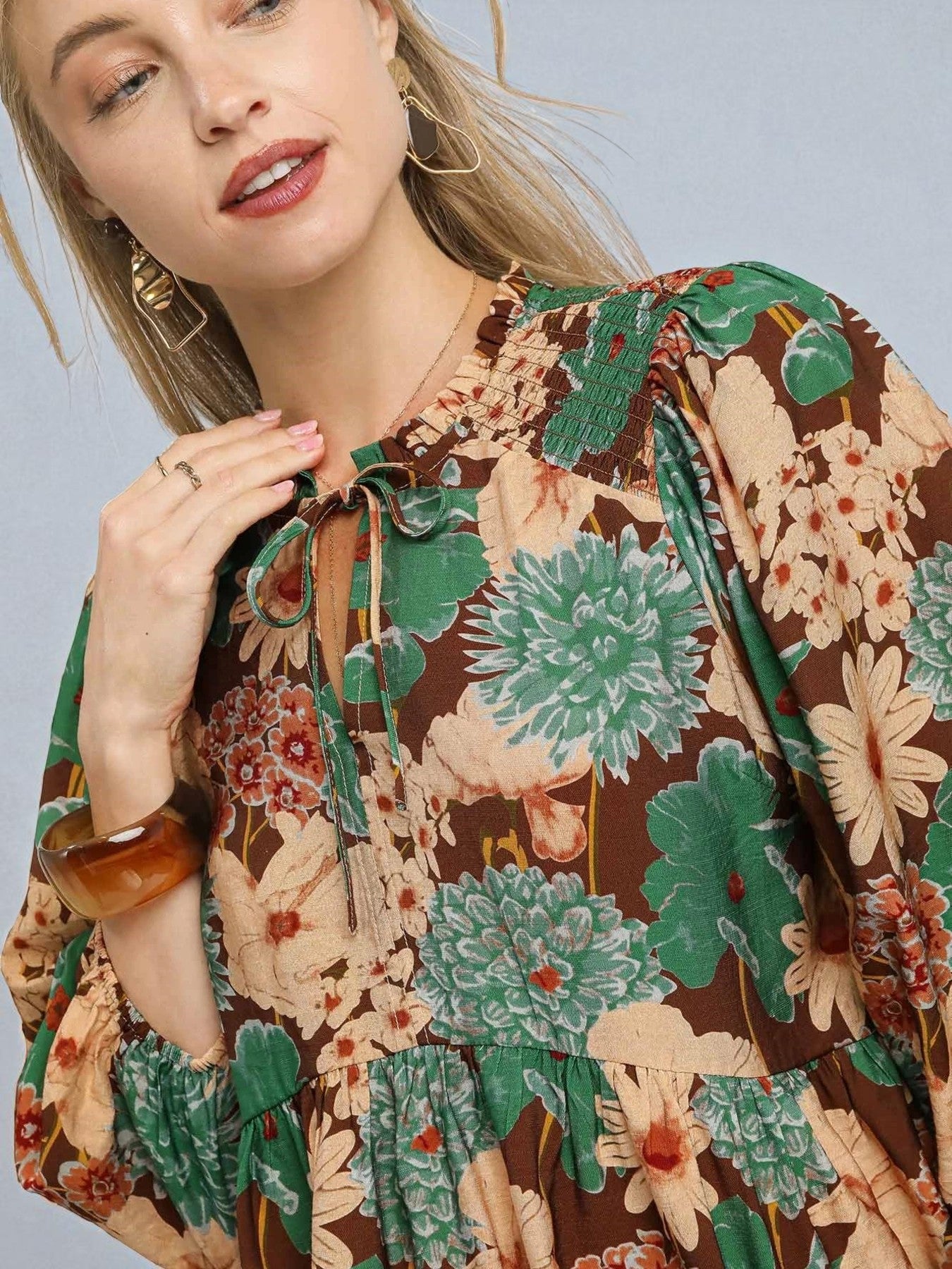 Woman wearing a floral blouse with a neutral background